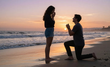 Couple sharing intimate beach proposal moment during sunset with man kneeling and presenting engagement ring
