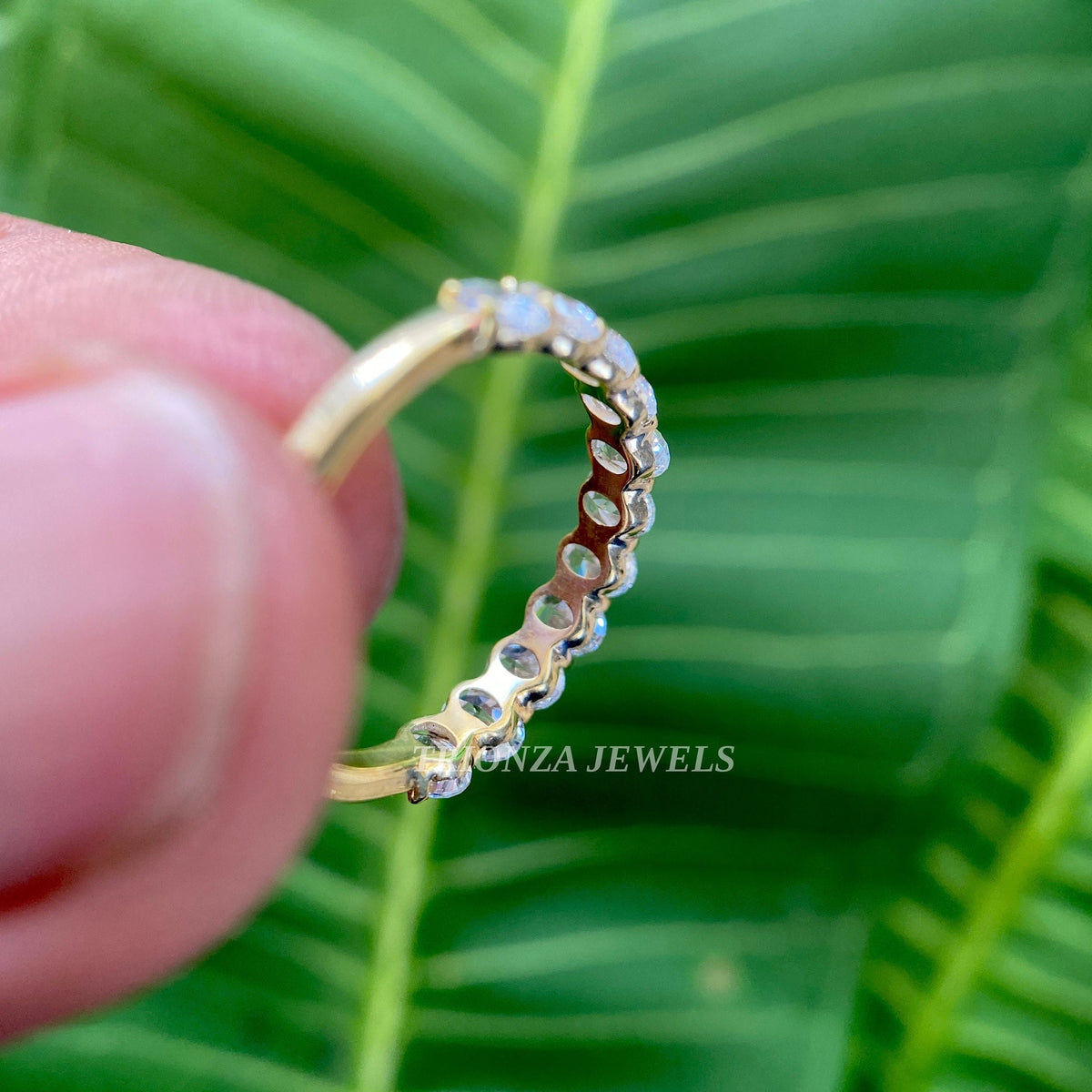 Side view of the oval cut moissanite band highlighting its excellent polish and symmetry