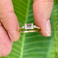Woman wearing the emerald solitaire moissanite ring as an elegant gold promise ring