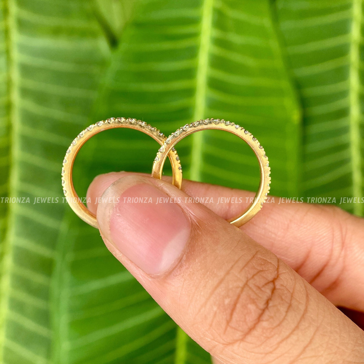 Close-up of the round cut moissanite stones set along the half eternity band