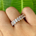 Solid gold stacking wedding band featuring 3x5mm brilliant cut oval moissanite stones