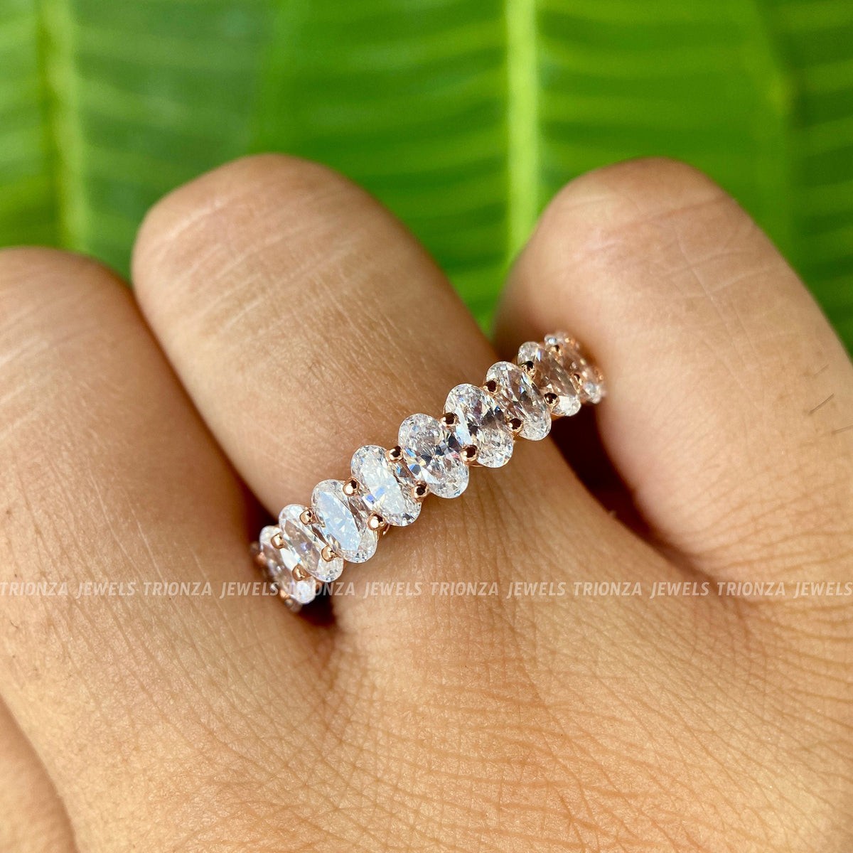 Solid gold stacking wedding band featuring 3x5mm brilliant cut oval moissanite stones
