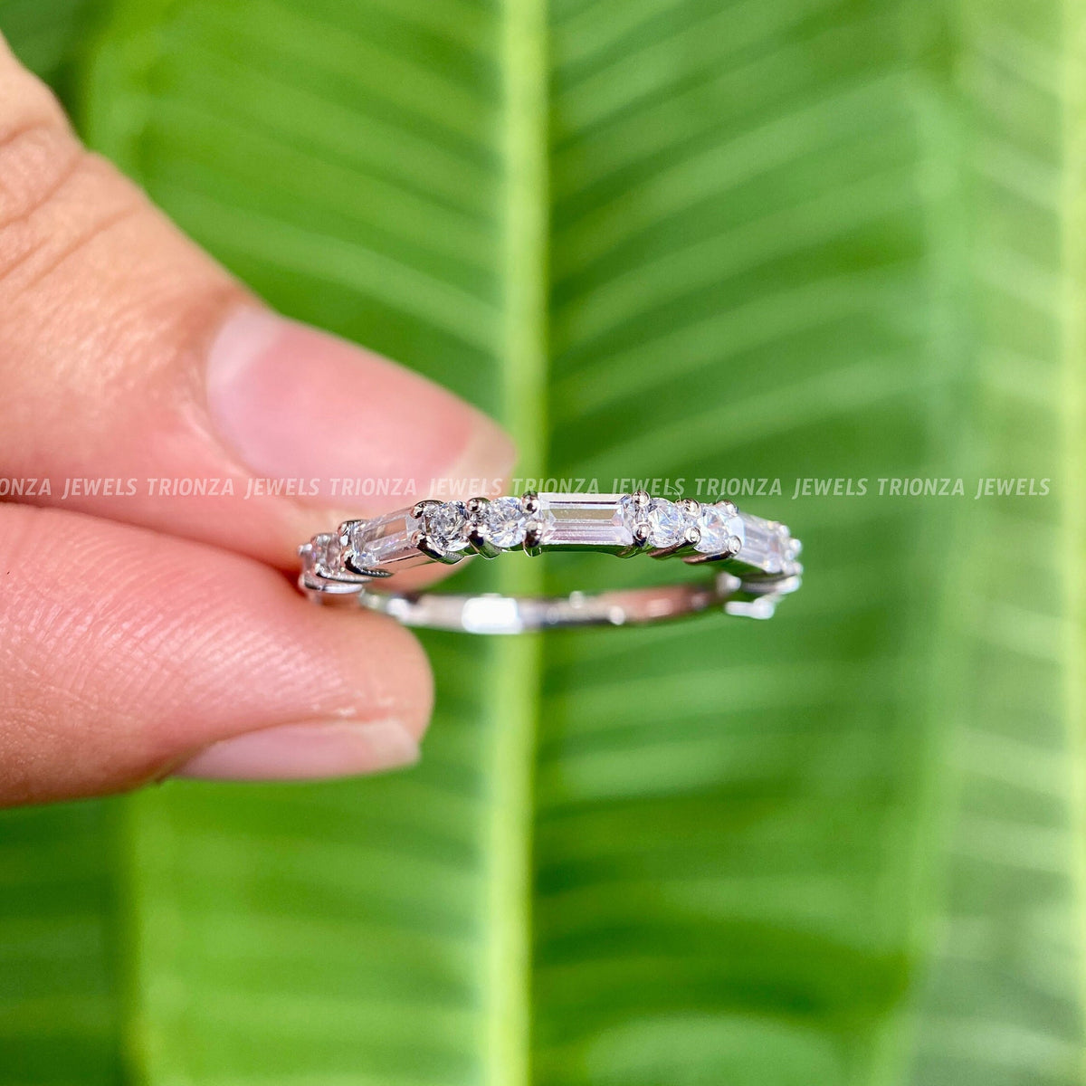 Close-up of the baguette and round moissanite stones set along the yellow gold band