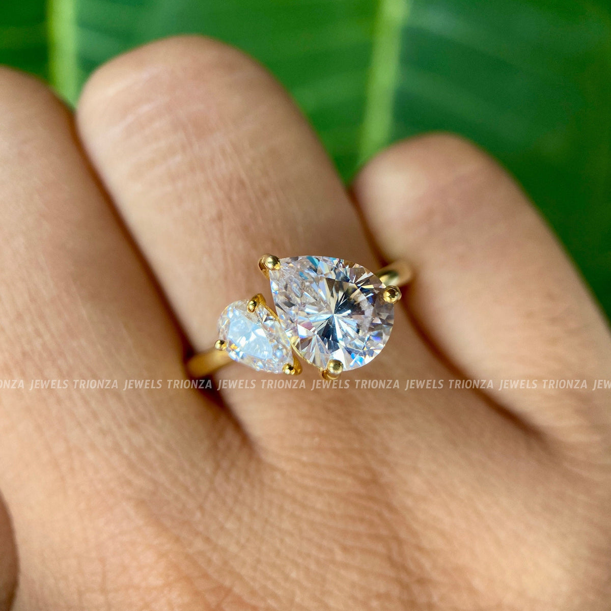 Close-up of the 1.25 CT pear cut moissanite set beside a 0.34 CT pear side stone