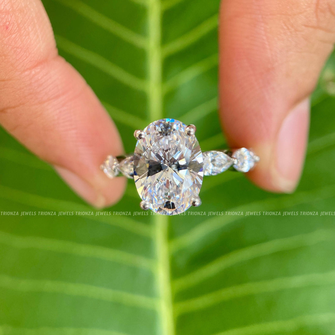 Elongated oval moissanite engagement ring featuring a hidden halo marquise pave setting