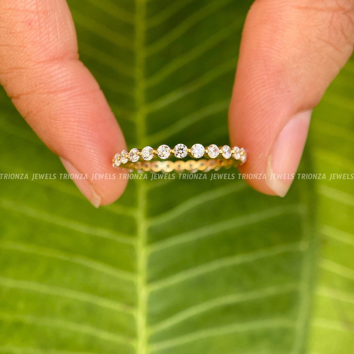 Full eternity moissanite band displayed in its jewelry box with a smooth cleaning fabric