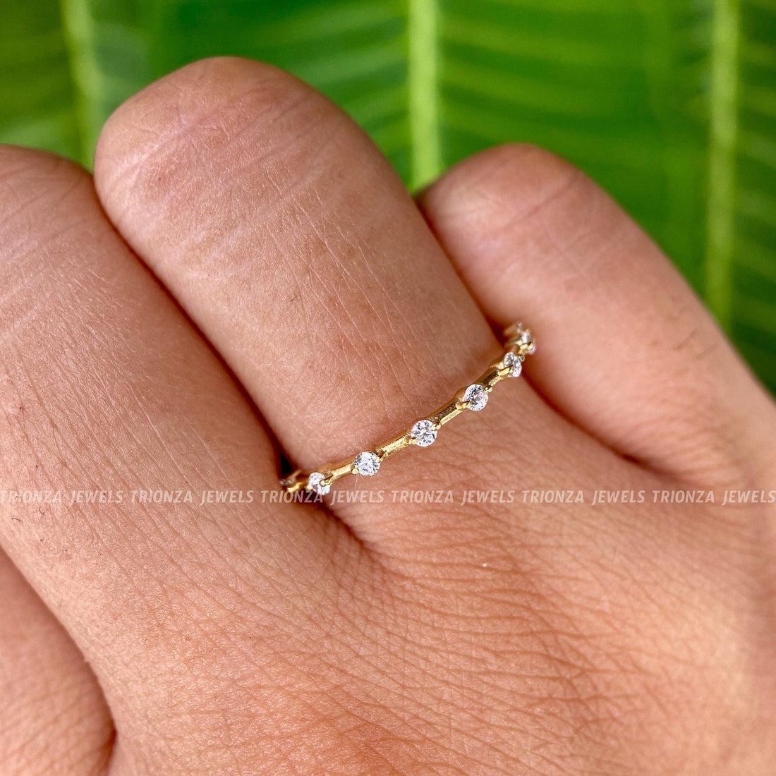 Round moissanite wedding band featuring a delicate bubble prong setting for stacking