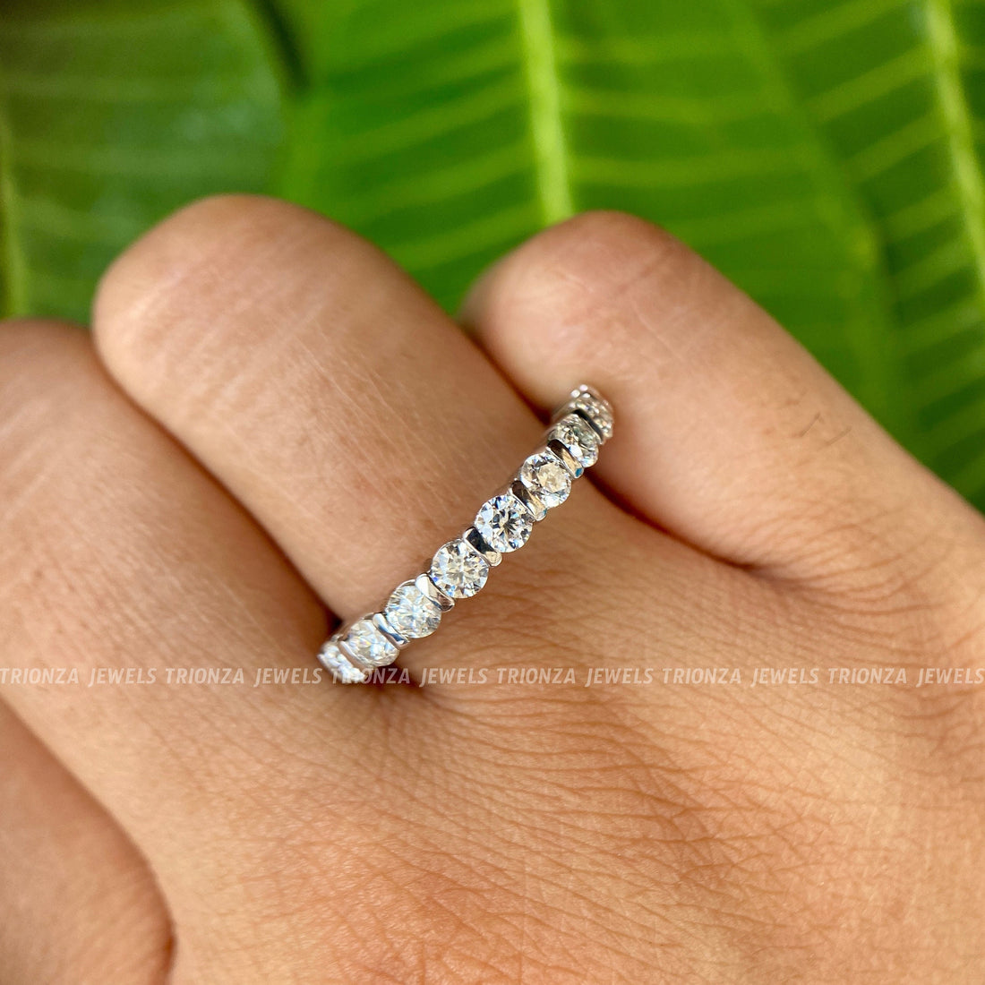 Round moissanite half eternity band featuring 2.50mm colorless stones set in a delicate ring