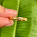 Solid gold vintage floral band ring displayed in a jewelry box showing its handmade design
