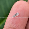 Loose lab grown shield diamond positioned for engagement ring side stone use