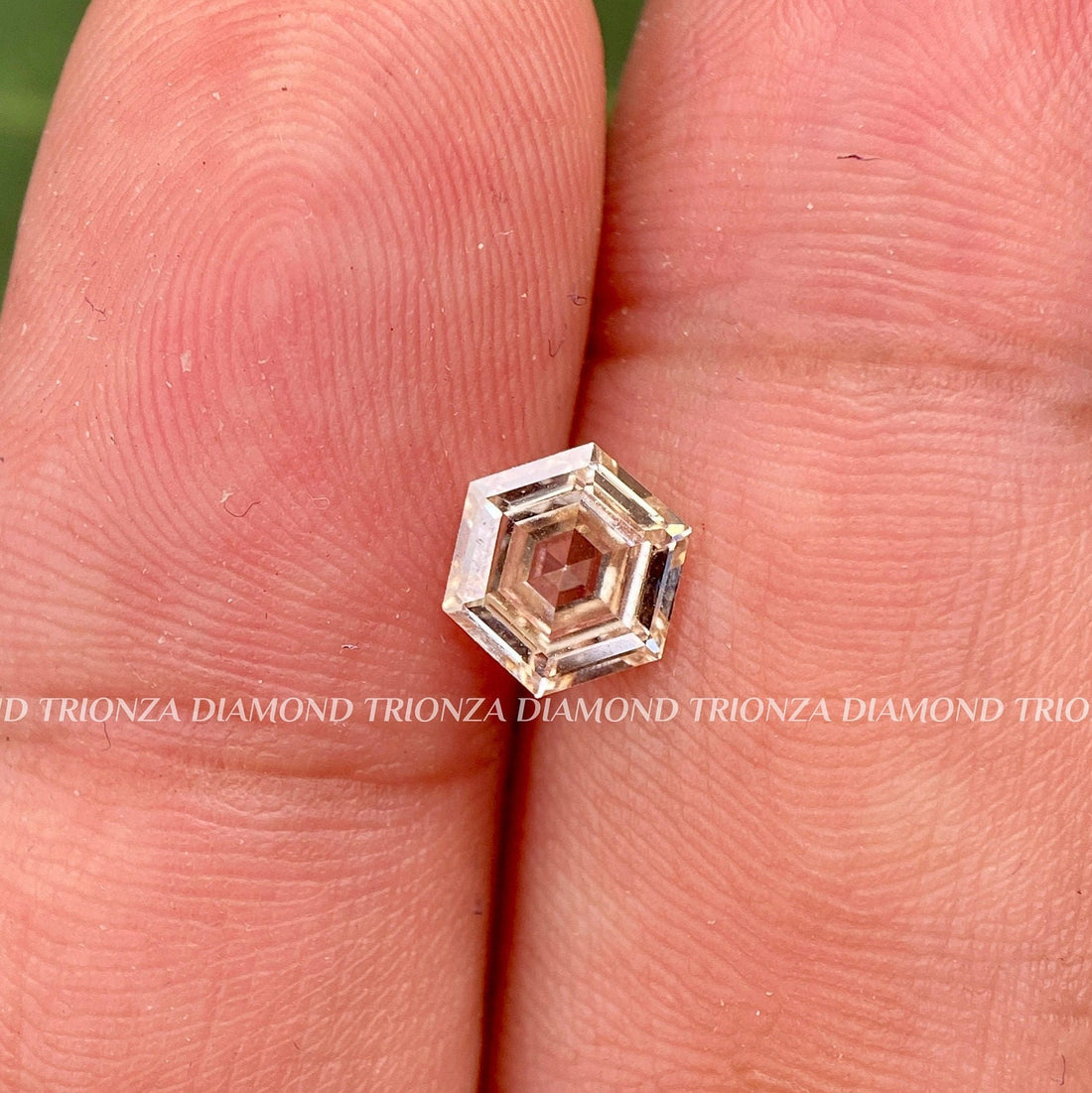 Hexagon step cut lab grown diamond displaying its intense brown color and faceted surface