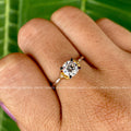 Round moissanite solitaire engagement ring displayed to highlight its prong halo setting