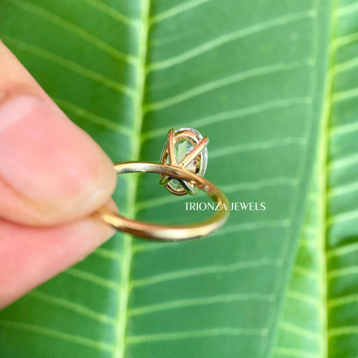 Close-up of the prong setting securing the elongated oval moissanite stone