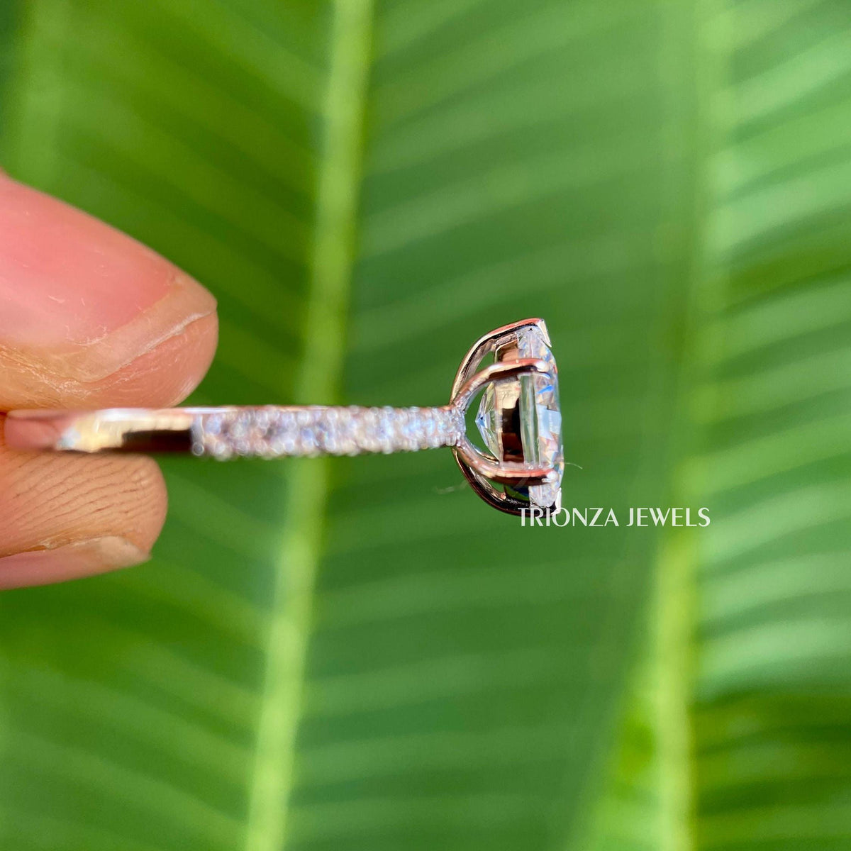 Round cut moissanite side stones accenting the oval solitaire engagement ring design