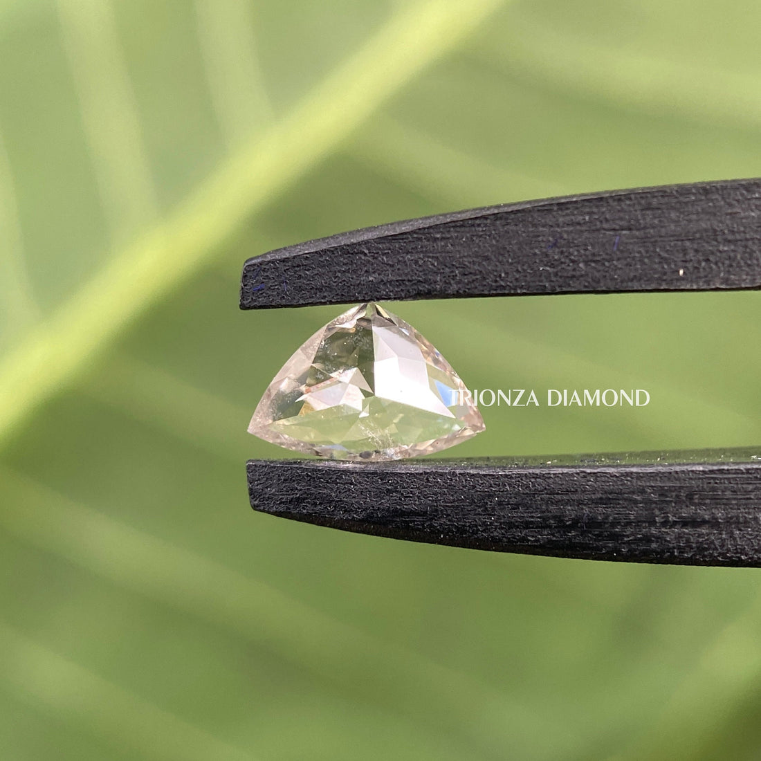 Curve trillion cut lab grown diamond displaying F color and VS2 clarity in a close-up view
