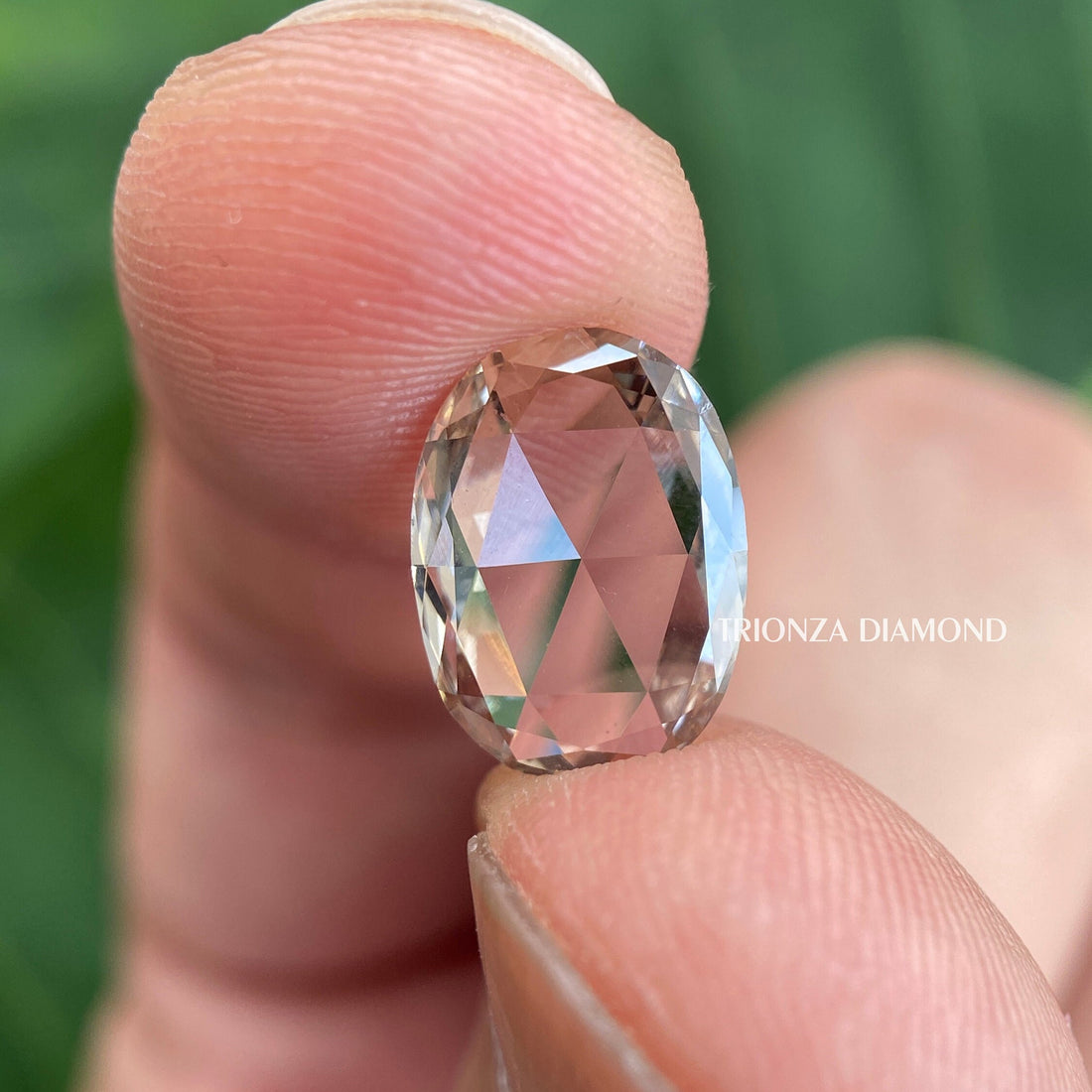 Oval rose cut lab grown diamond displayed to showcase its flat cut vintage style facets