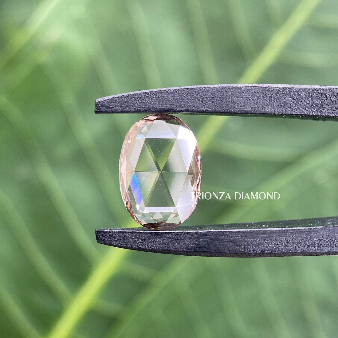 Oval rose cut lab grown diamond displayed to showcase its flat cut vintage style facets