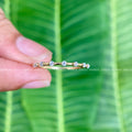 Round moissanite wedding band featuring a delicate bubble prong setting for stacking