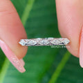 Vintage art deco moissanite wedding band featuring milgrain detailing along a straight half eternity design