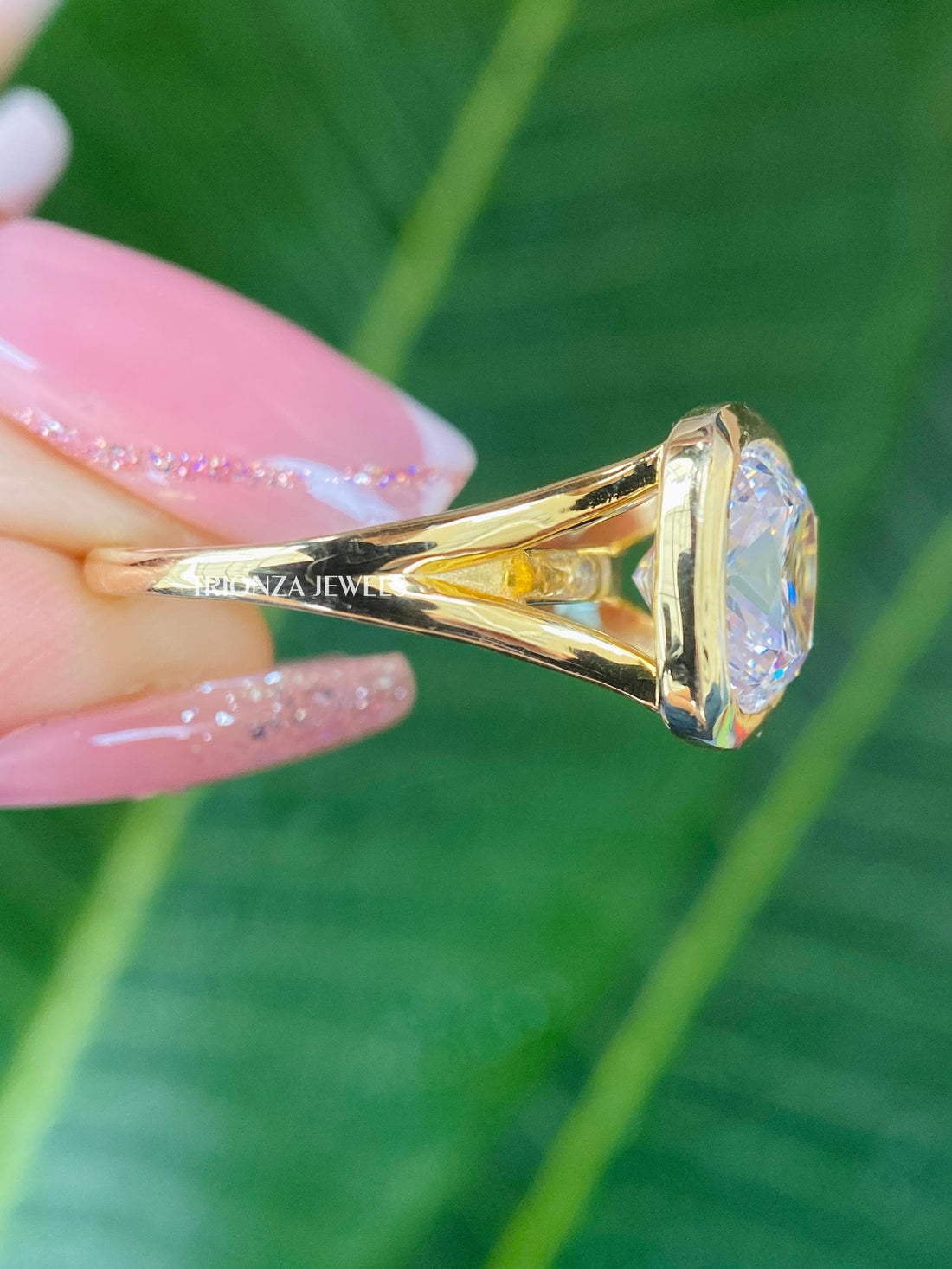 Cushion cut moissanite ring featuring a bezel setting in solid white gold