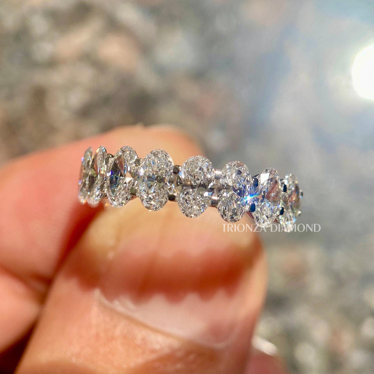 Oval cut lab grown diamond half eternity band displayed as a stackable wedding ring for her