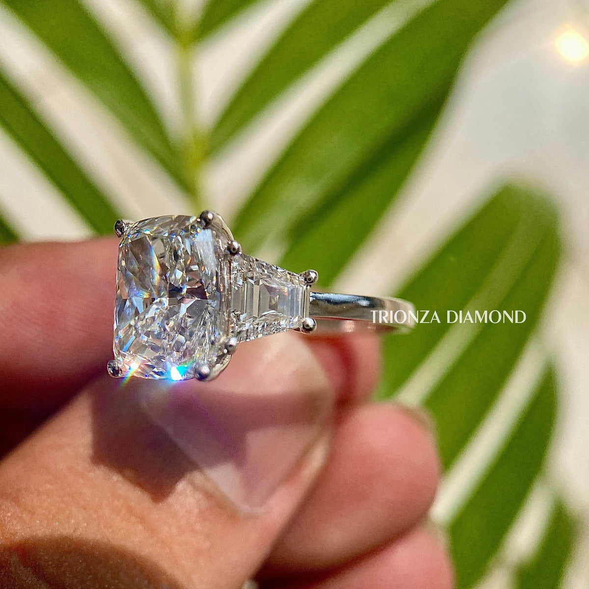 Three stone engagement ring showcasing a 5 carat cushion cut center diamond design
