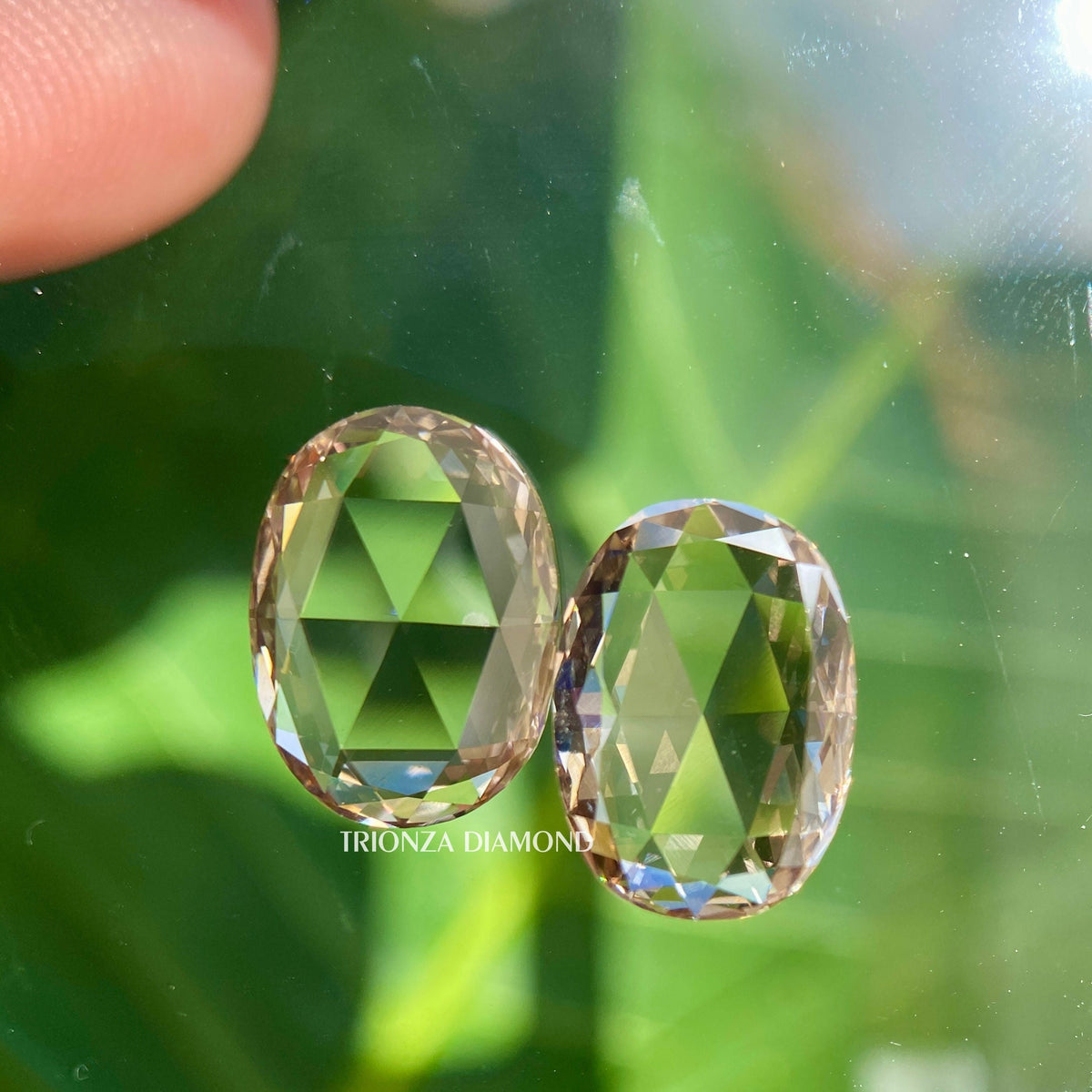 Oval rose cut lab grown diamond pair displayed showing intense brown color and flat cut facets