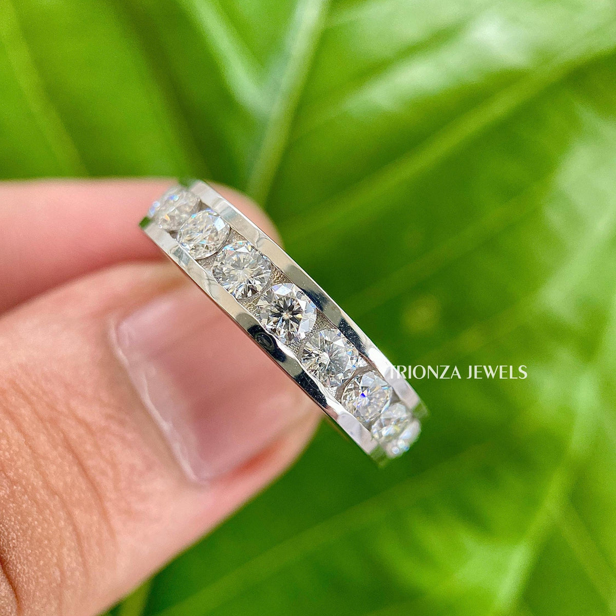 Channel set moissanite wedding band featuring round stones set in 14k gold
