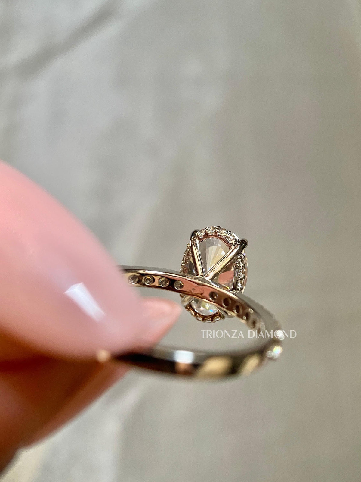 Woman wearing the oval diamond engagement ring displayed on her hand in natural light