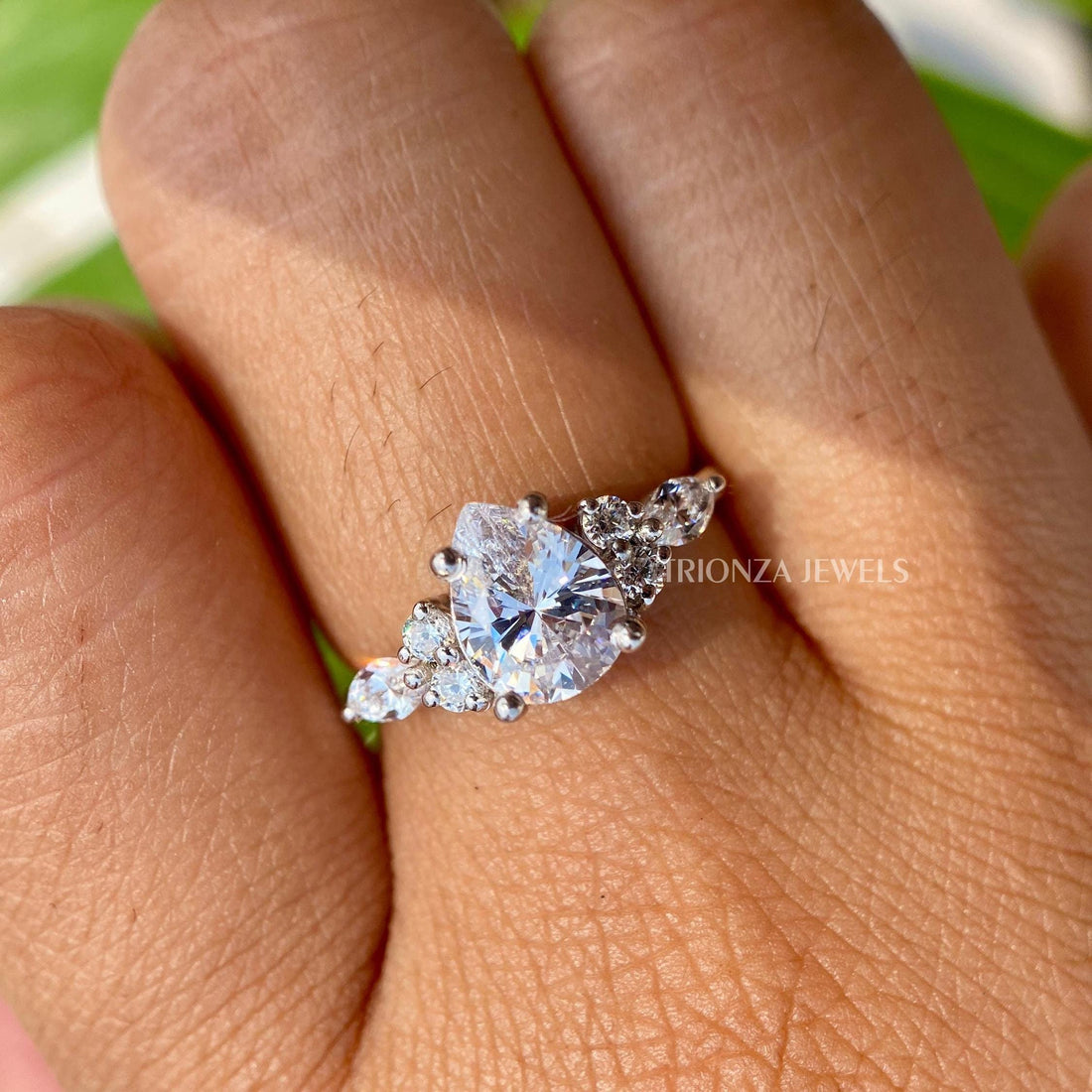 Pear cut moissanite engagement ring displayed to highlight its thin band solitaire design