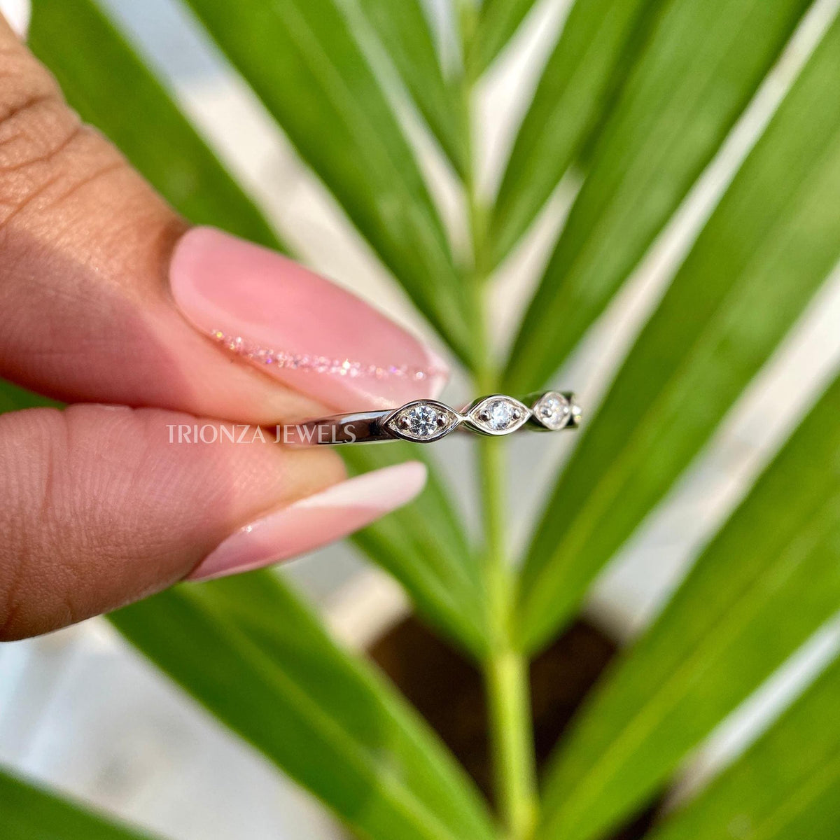 Close-up of the prong and bezel setting securing each round moissanite stone