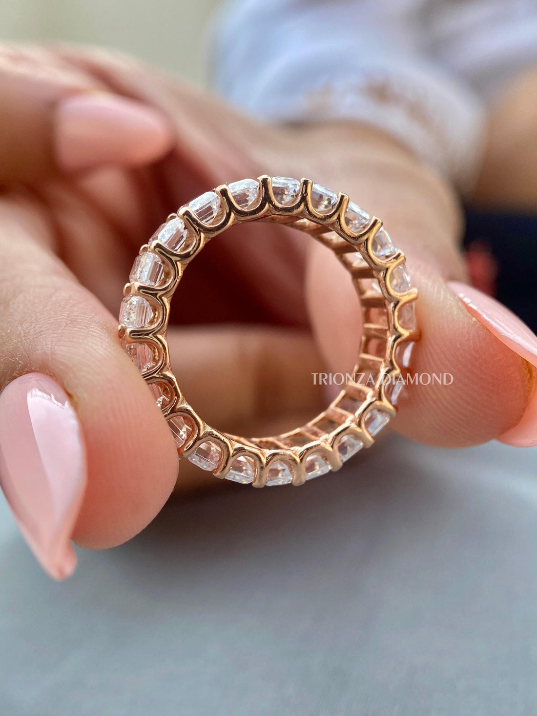 Emerald cut lab grown diamond eternity band displayed with its rose gold U-prong setting