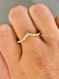 Close-up of the round cut diamonds showing D/E color and VVS/VS clarity along the curved band