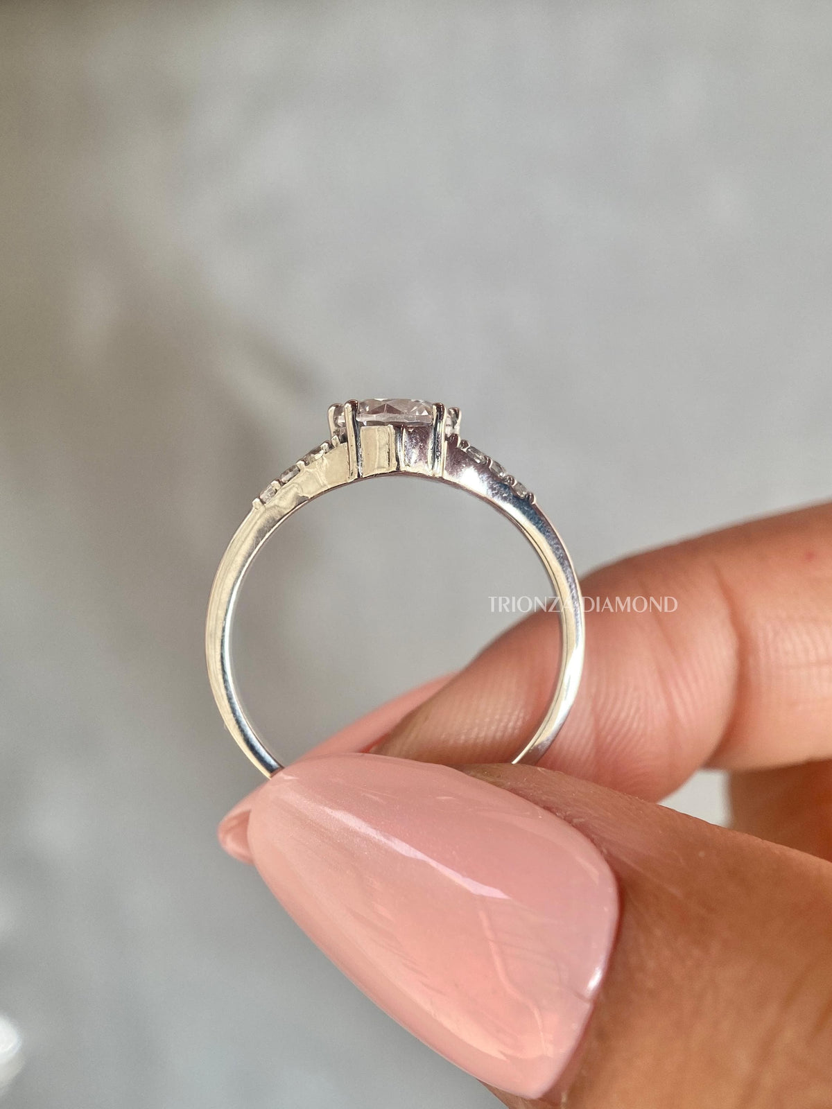 Woman wearing the round diamond engagement ring, showcasing its brilliant solitaire design