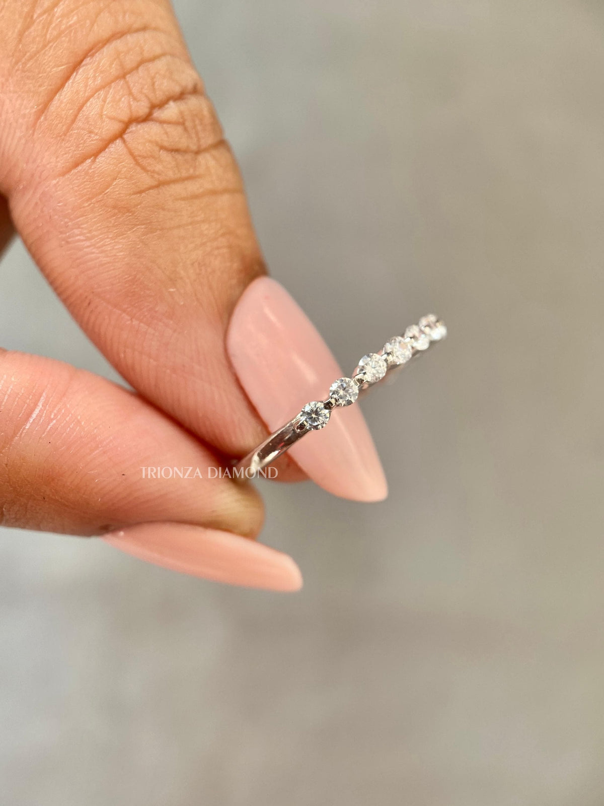 Close-up of the 1.50 MM round cut lab diamonds set along the single prong wedding band