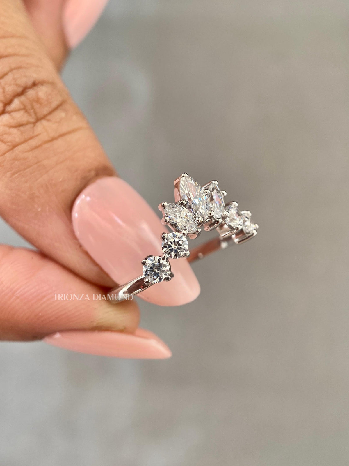 Close-up of the marquise diamond and round accent stones set along the curved band