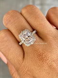 Halo engagement ring displaying the radiant cut center stone alongside round accent diamonds