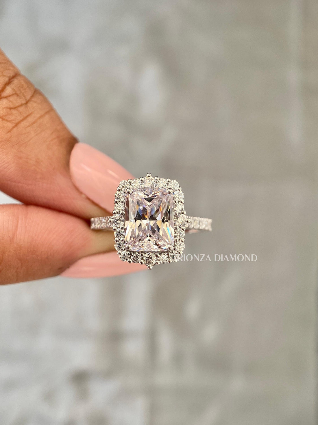 Radiant cut lab grown diamond engagement ring featuring a halo of round brilliant side stones