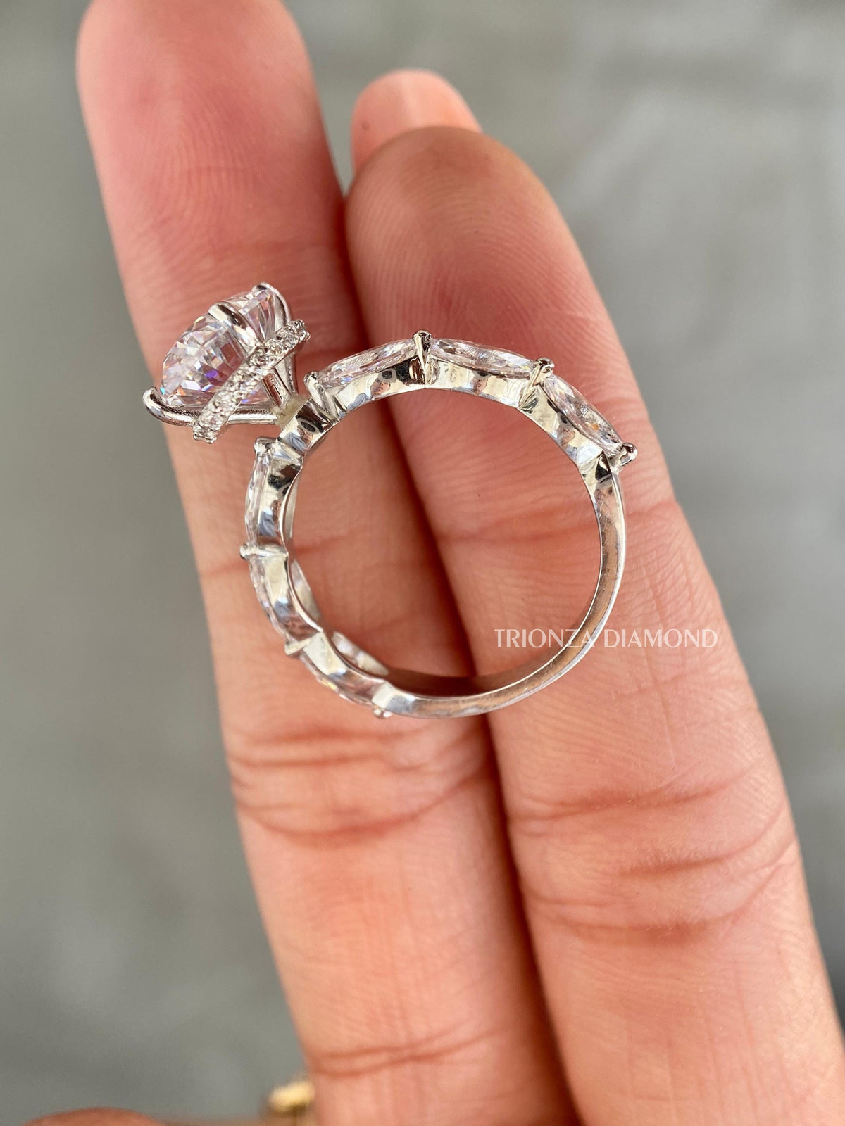 Marquise accent diamonds framing the oval center stone in a clean bridal silhouette