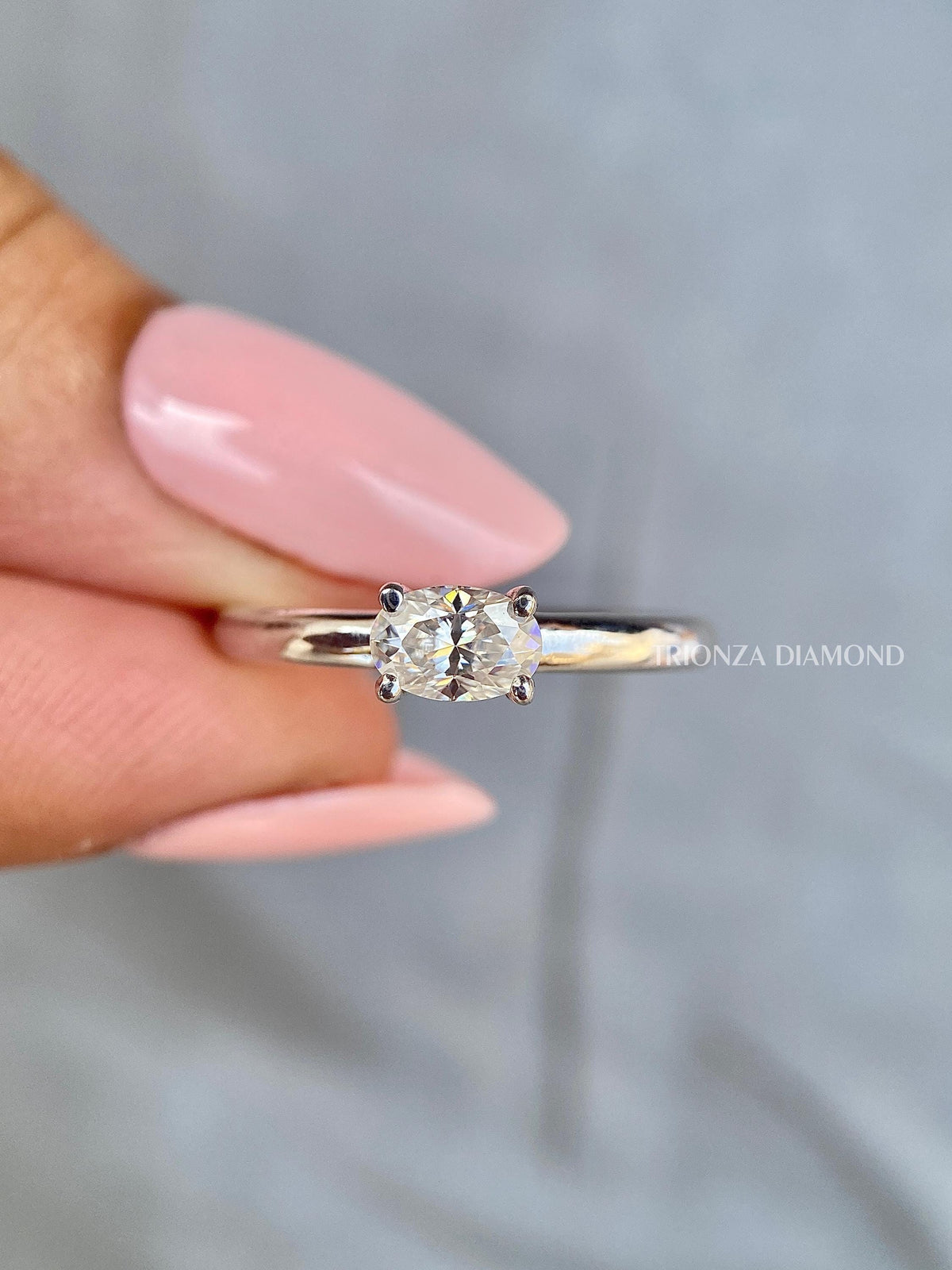TrionzaDiamond solitaire ring featuring an east west set oval lab grown diamond