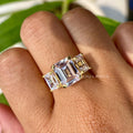 Three stone emerald cut moissanite engagement ring displayed in its jewelry box with smooth fabric