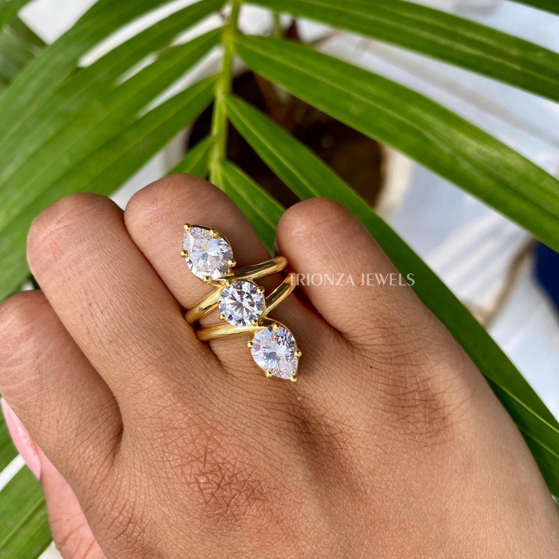 Vintage art deco engagement ring featuring a pear and round cut moissanite center stone