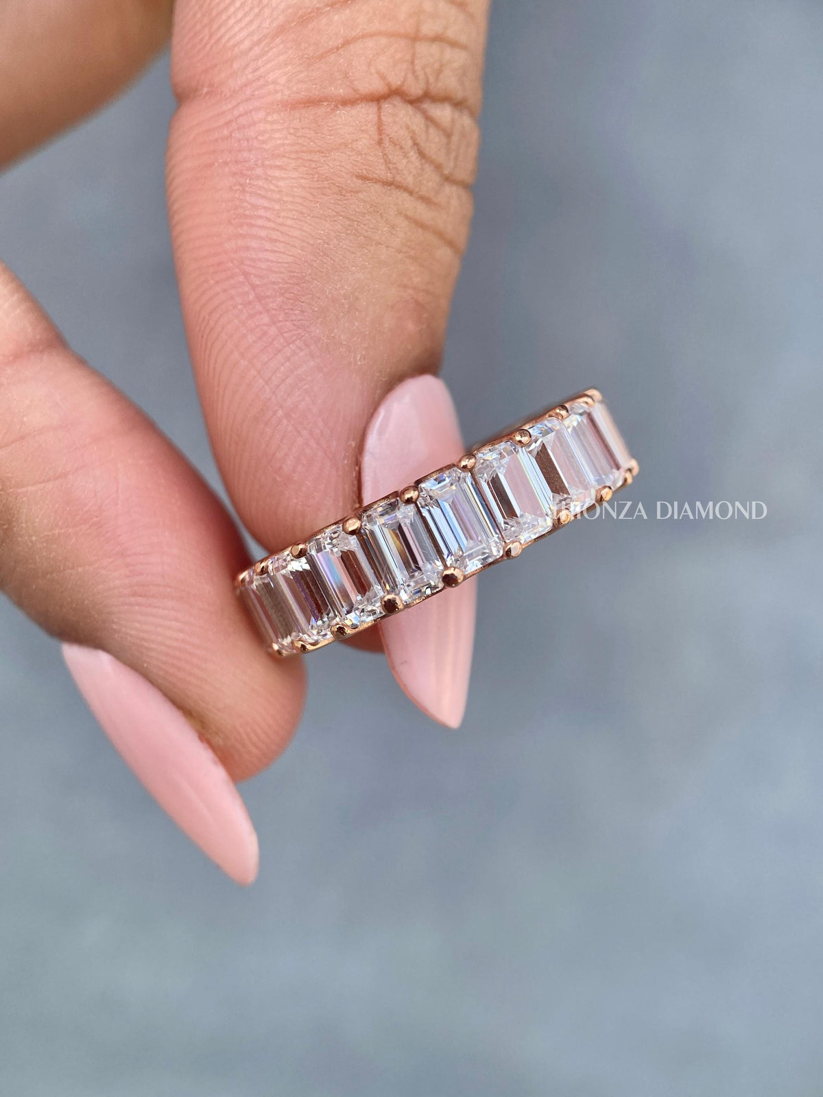 Rose gold full eternity ring showcasing continuous emerald cut diamonds around the band