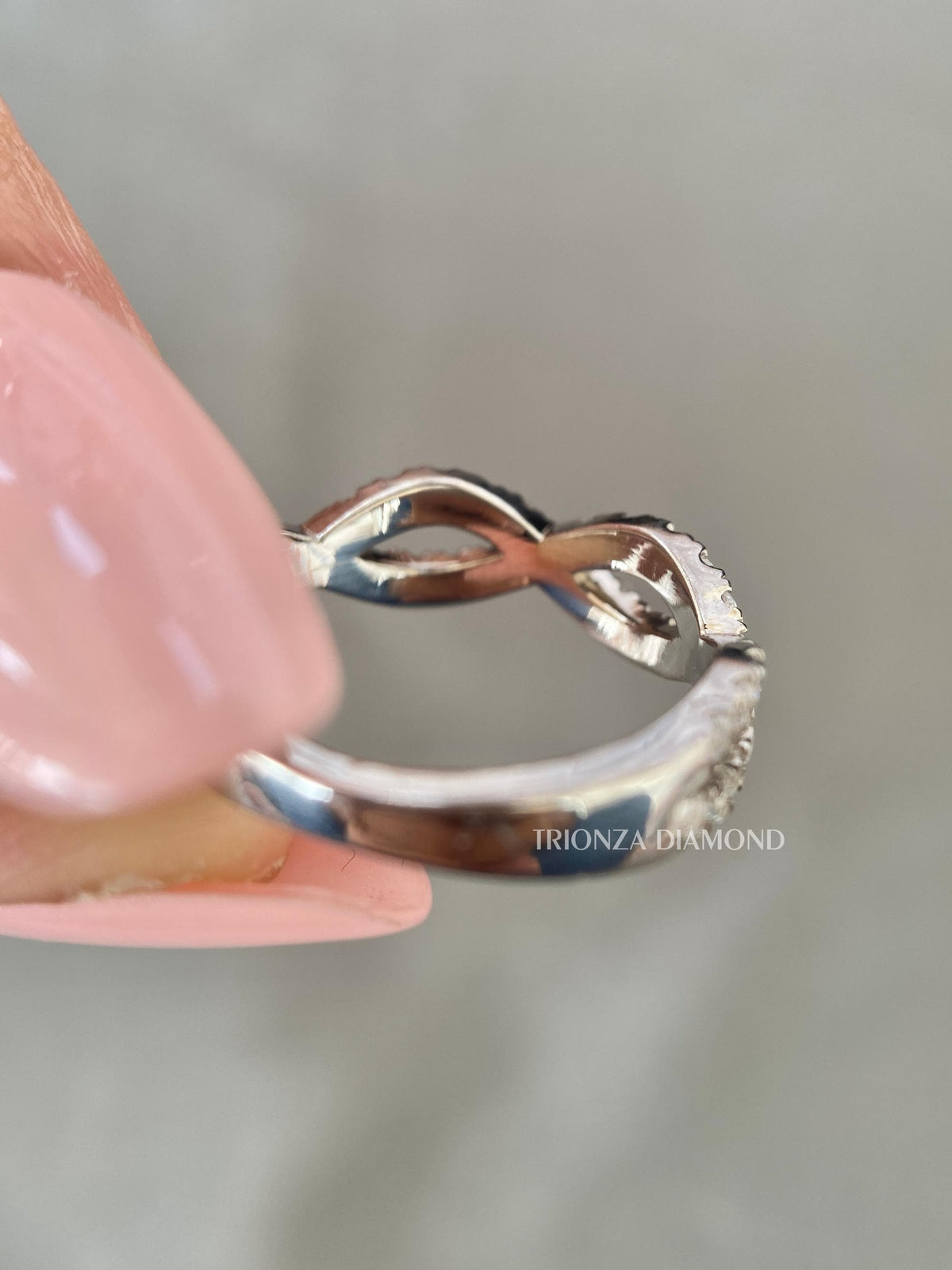 Woman wearing the infinity twist diamond eternity band for an everyday stackable look