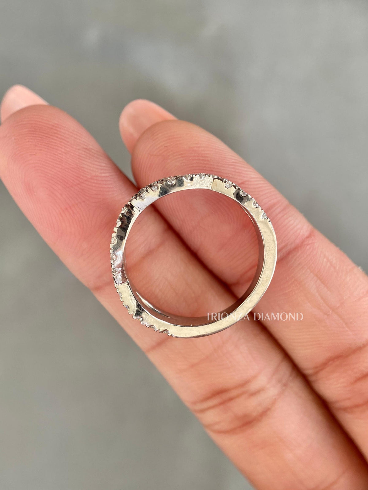 Stackable ethical diamond ring displayed to highlight its elegant infinity style pattern