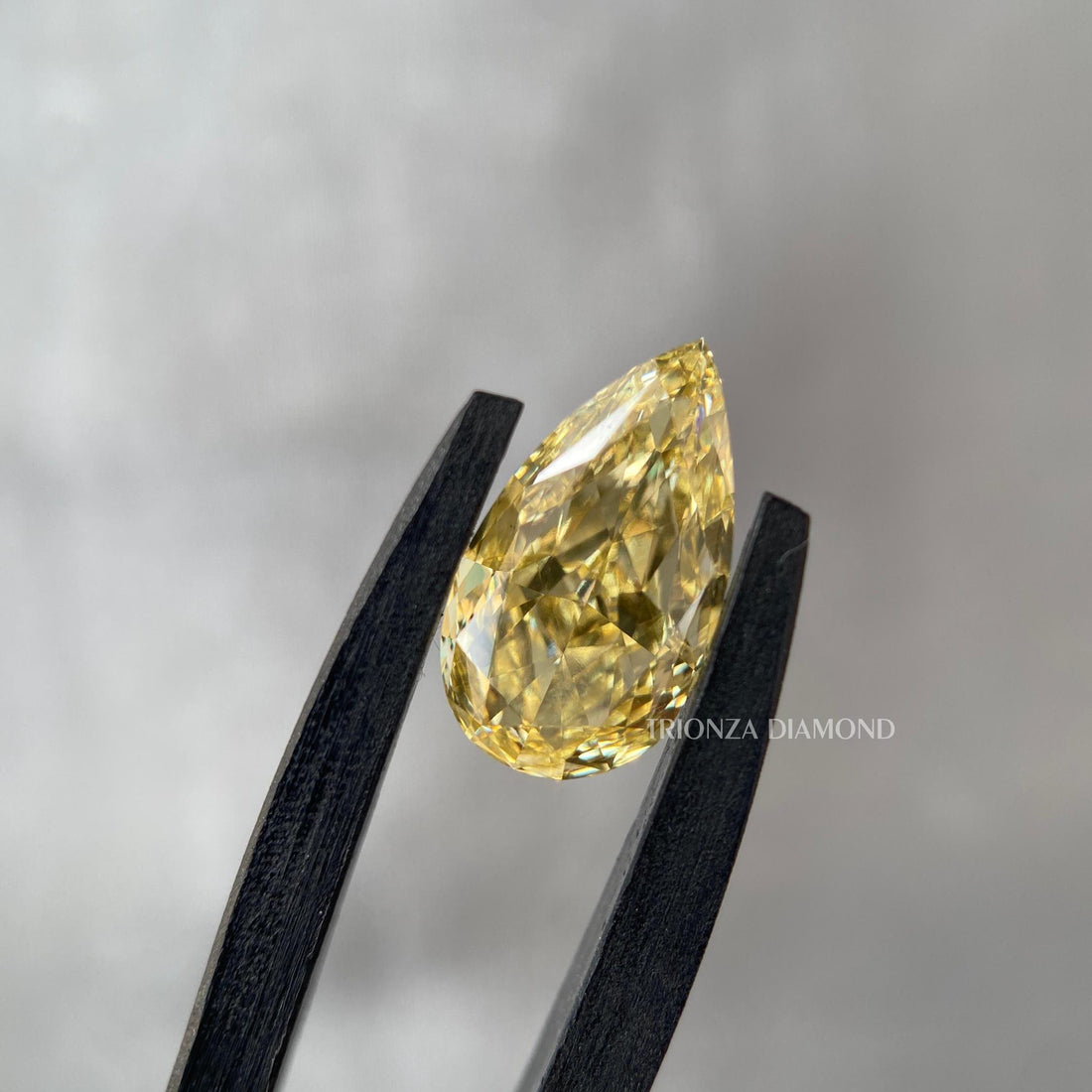Pear cut yellow lab grown diamond engagement ring showcasing a fancy intense yellow color
