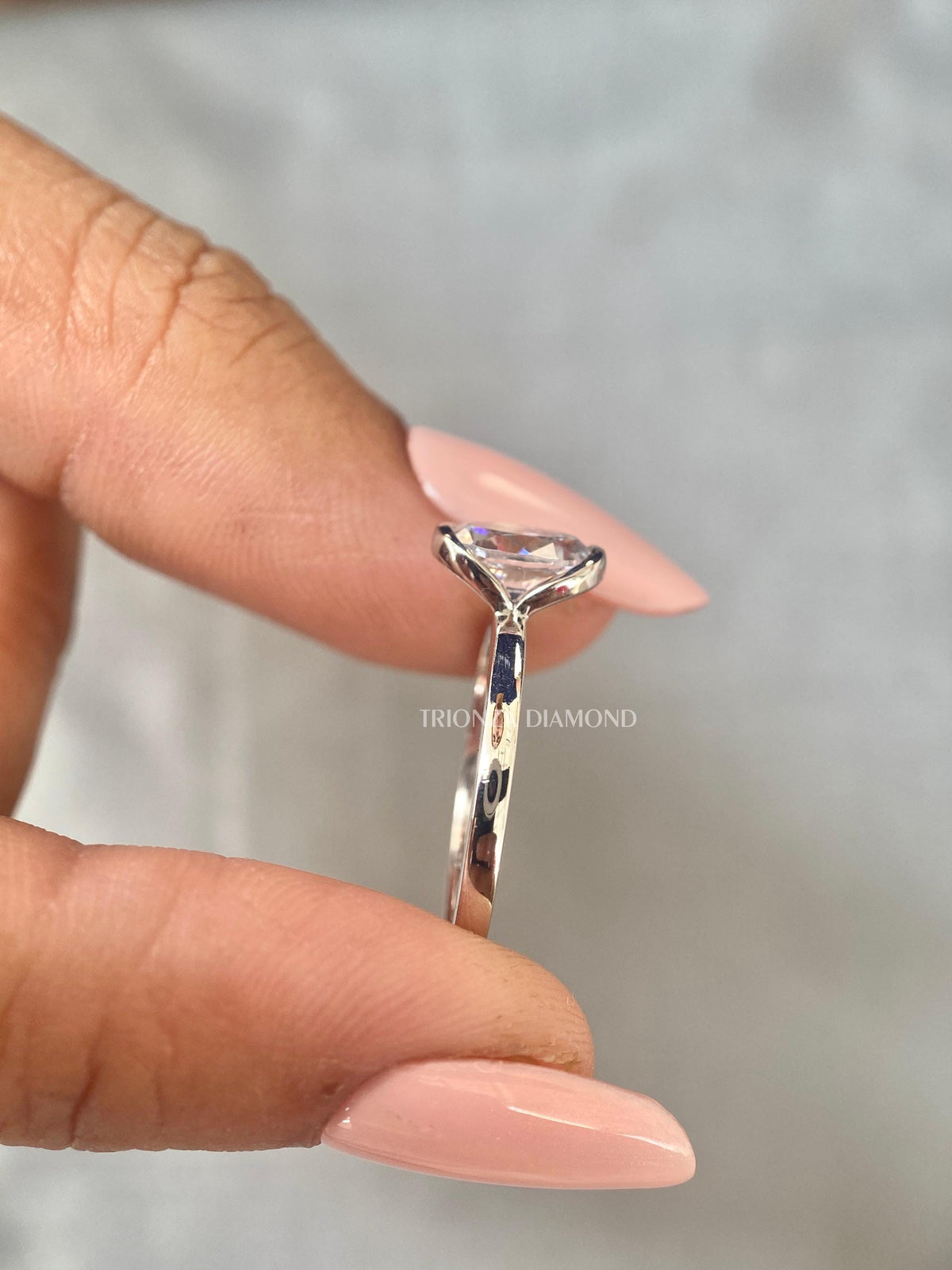 Close-up of the half bezel setting securely holding the 6x8 mm oval diamond
