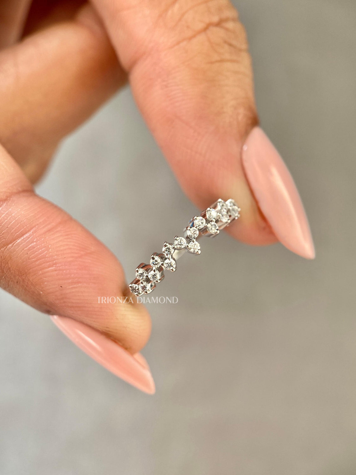 Woman wearing the round diamond half eternity band stacked with a matching ring