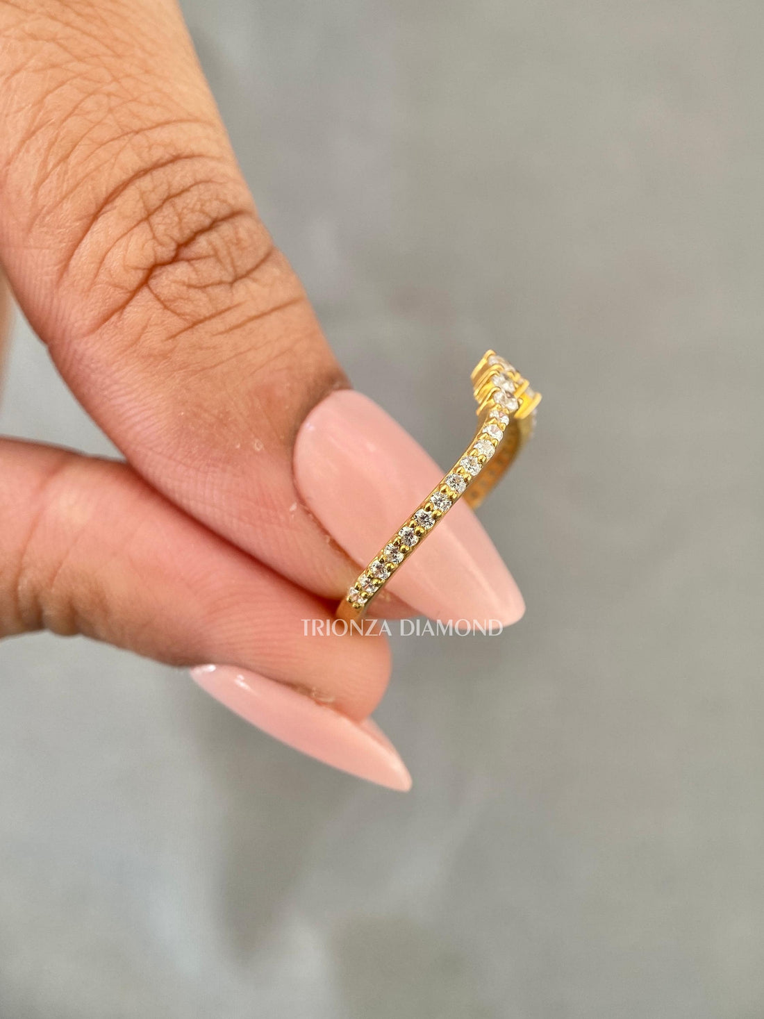 Curved 14k gold wedding band featuring round cut lab grown diamonds set in a thin design