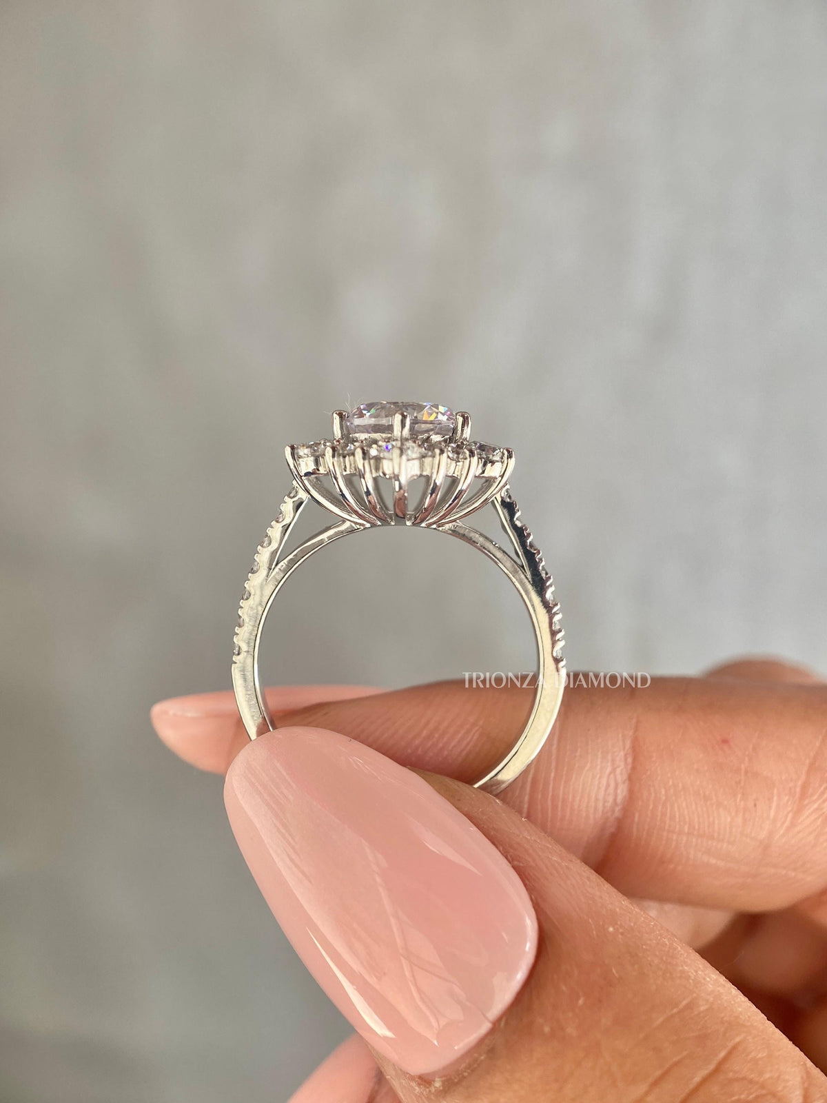 Close-up of the 2 carat round cut center diamond set in a starburst halo setting